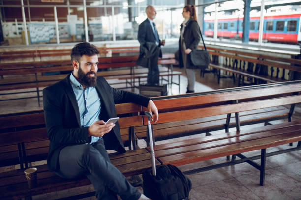 istock Businessman using mobile phone at train station 918879630