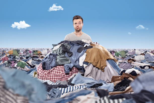 man in a mess of laundry - overstrained imagens e fotografias de stock