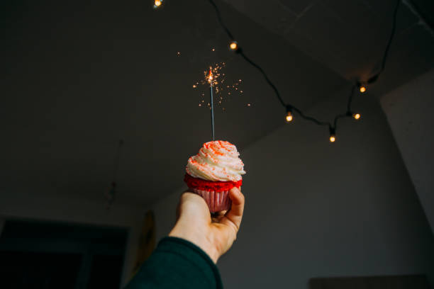 istock Hand holds pink sweet cupcake with sparkle 918880566