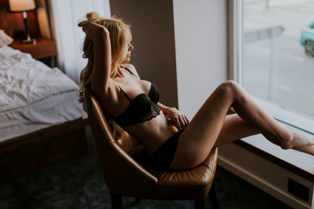 istock Young woman posing in lingerie by window 918881142