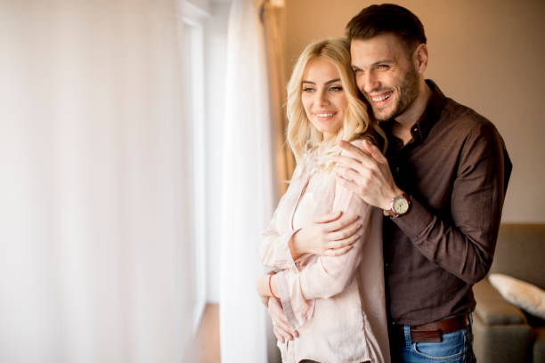 istock Loving couple by window in the room 918881176