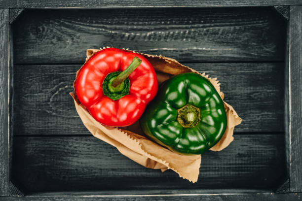 vista superior de los pimientos rojos y verdes en bolsa de papel que hace compras - green bell pepper bell pepper red bell pepper groceries fotografías e imágenes de stock