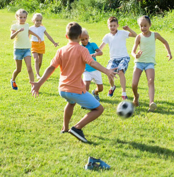 istock children playing football on meadow 918897036