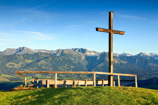 Wooden summit cross with scenic view to mountain range Wooden summit cross with sublime view to a mountain range. Ofterschwanger Horn, Bavaria, Germany. ofterschwang stock pictures, royalty-free photos & images