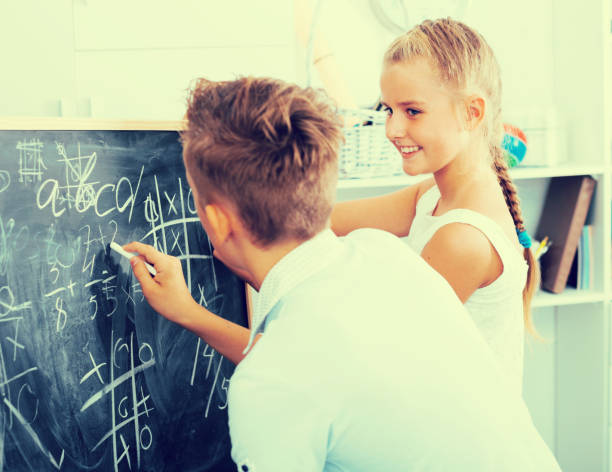 istock Friends are learning new theme on math and writing task on desk 918918558
