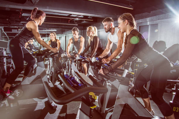 fit ludzi pracujących na zajęciach w klasie ćwiczeń na siłowni. - spinning gym cycle cycling zdjęcia i obrazy z banku zdjęć