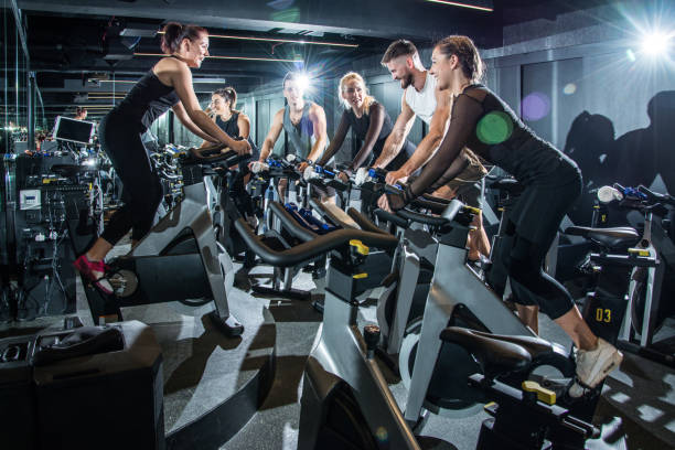 istock Group of sporty people training on exercise bikes together at gym. 918931168