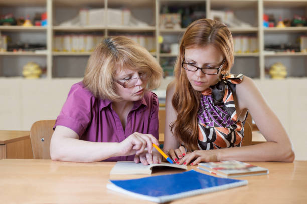 istock Teacher teaches a student at a table in the classroom 918935020