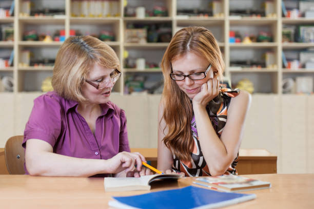 istock Teacher teaches a student at a table in the classroom 918935024