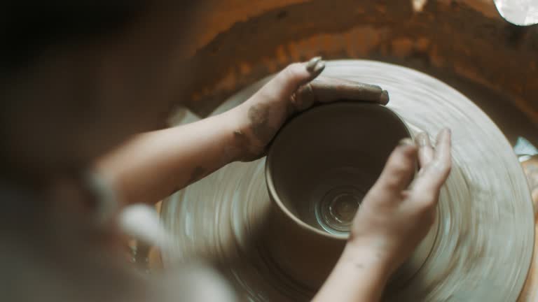 Close-up, little girl using pottery wheel at atelier