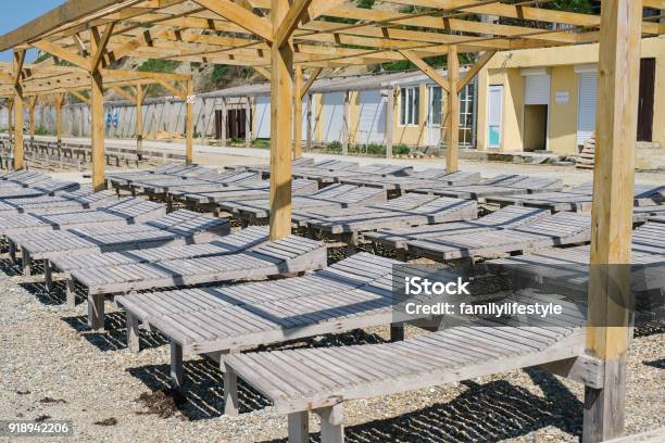 Wooden Sun Loungers On A Pebbled Public Beach By The Sea Closeup Side View Stock Photo - Download Image Now
