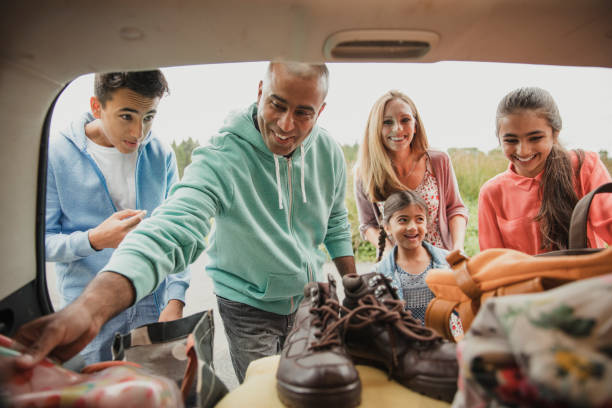 Unpacking the car Inside view of car boot as family unpack the car. northern europe family car stock pictures, royalty-free photos & images