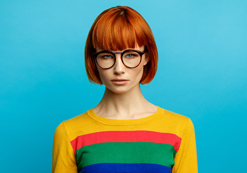Colorful portrait of young woman with red hair and glasses