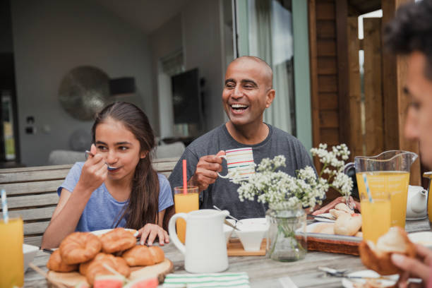 Morning Coffee Outside Father laughing and having a morning coffee outside holiday cottage. egyptian ethnicity stock pictures, royalty-free photos & images