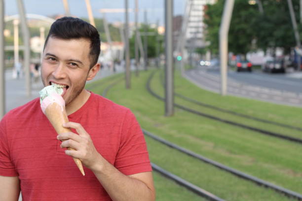 istock Man licking an ice cream with copyspace 918950588
