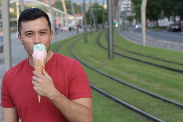 istock Man licking an ice cream with copyspace 918950746