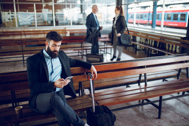 istock Businessman using mobile phone at train station 918950876