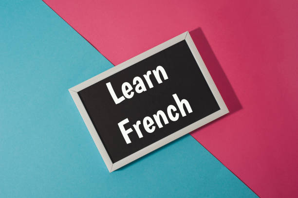 istock Learn French - text on chalkboard on blue and pink bright background. 918951444