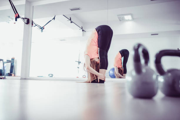 istock Young Athlete Female Stretching in the Gym Before Training 918954716