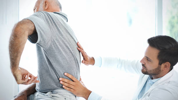 istock Senior man having his back examined by a doctor. 918958610