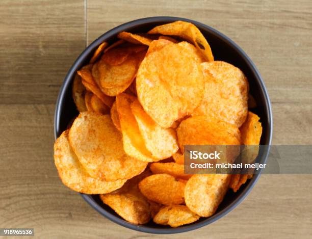 Spiced Paprika Potato Chips In A Bowl On A Wooden Background Stock Photo - Download Image Now