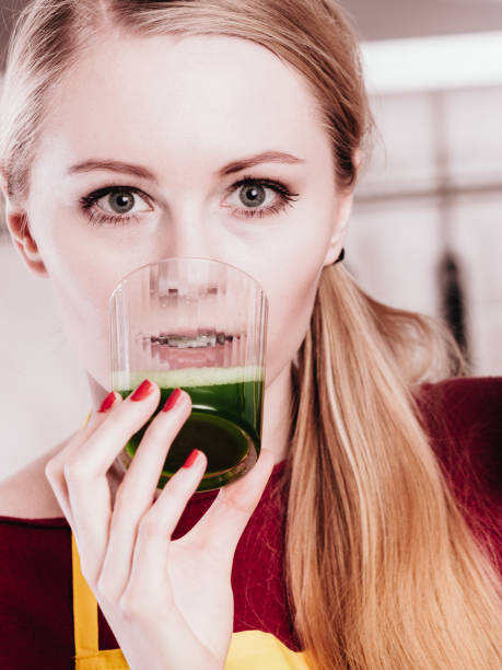 istock Woman in kitchen holding vegetable smoothie juice 918974392