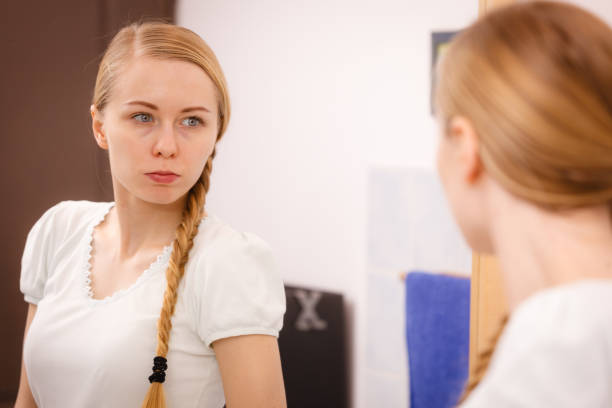 istock Woman looking at her reflection in mirror 918974502