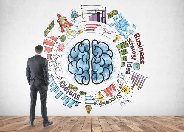 istock Businessman looking at brain sketch 918975232