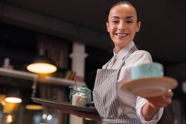 istock Careful confident waitress bringing tea 918978516