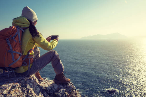 istock Young Woman Hiker Using Smartphone while hiking at Seaside 918978568