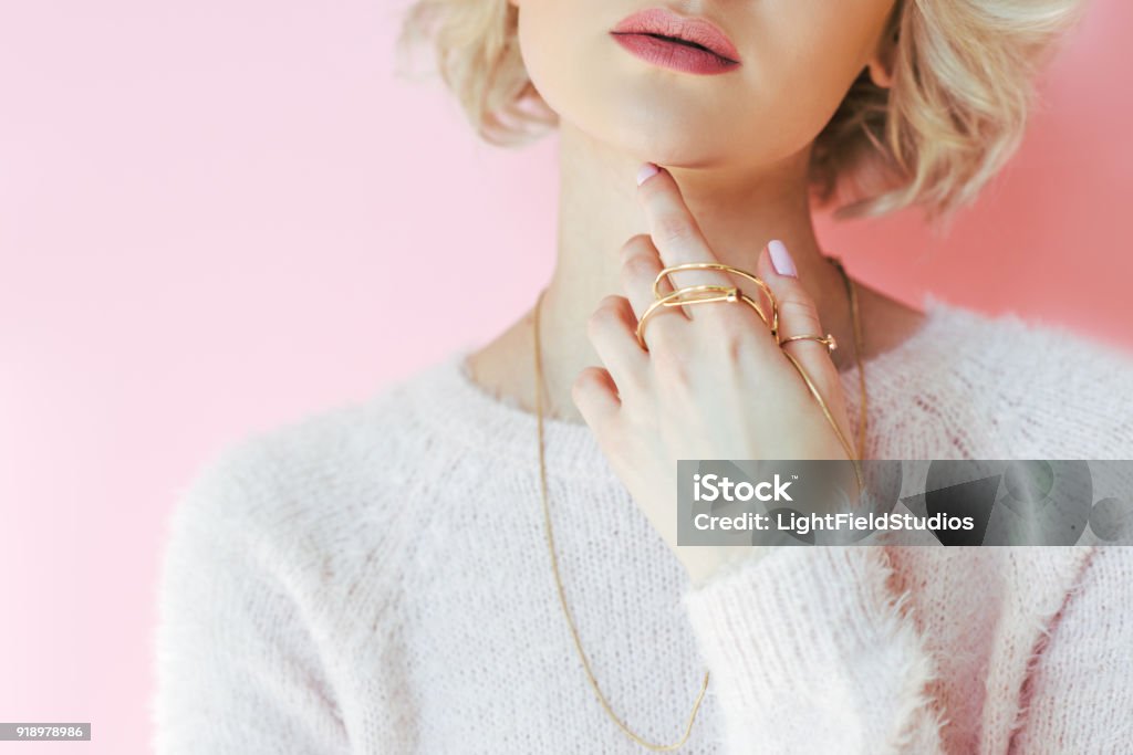 cropped shot of sensual young woman holding jewelry in hand isolated on pink Jewelry Stock Photo