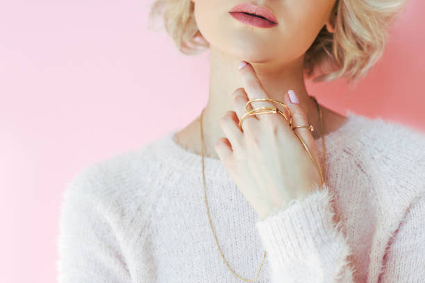 cropped shot of sensual young woman holding jewelry in hand isolated on pink - charming imagens e fotografias de stock