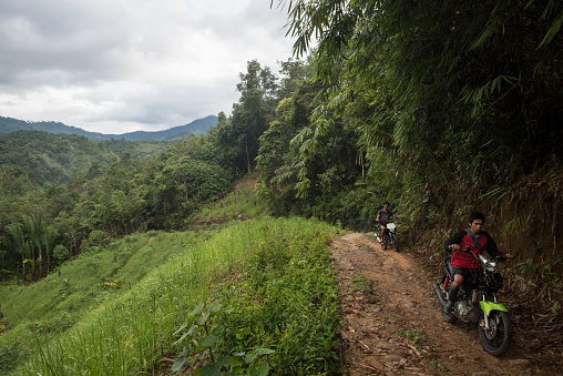 In Indonesia's South Kalimantan province, two motorbikes travel on the rustic path between the town of Loksado and more rural villages in the countryside. (March 2, 2017)