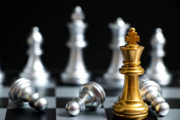 istock Gold King in chess game face with the another silver team on black background (Concept for company strategy, business victory or decision) 918981538