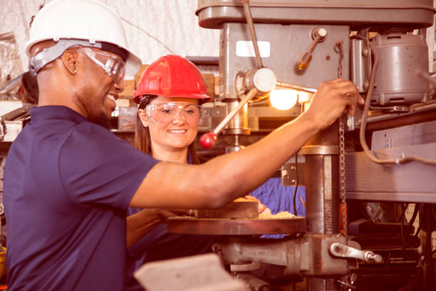 istock Industrial workers use drill press equipment together in factory. 918982364