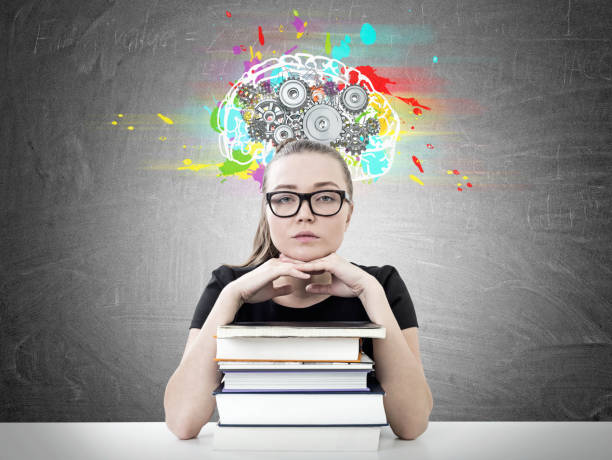 istock Serious blonde student, books, cog brain 918988214