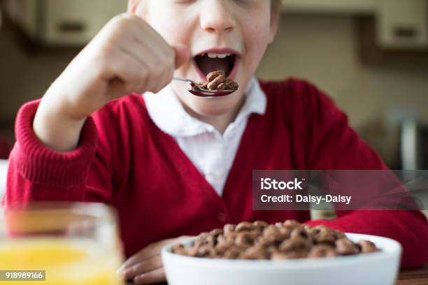 Close Up Of Girl Wearing School Uniform Eating Bowl Of Sugary Breakfast Cereal In Kitchen Stock Photo - Download Image Now
