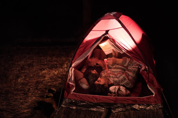 istock Father and son camping and reading bedtime stories in tent 918994428
