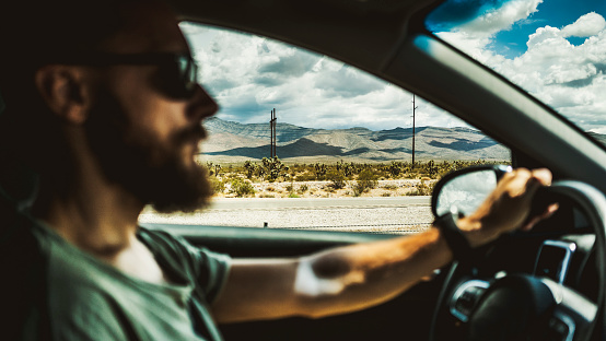 Driving a car on desert highway POV