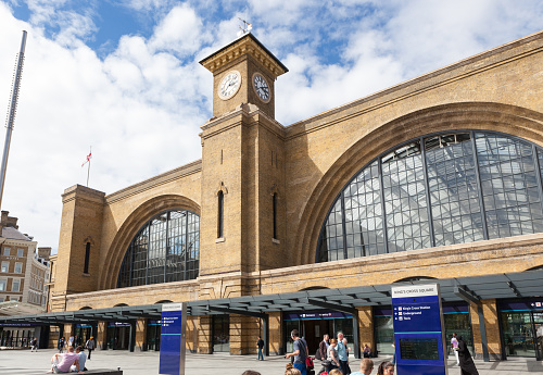 Facade of Kings Cross Railway Station, London, with people outside.