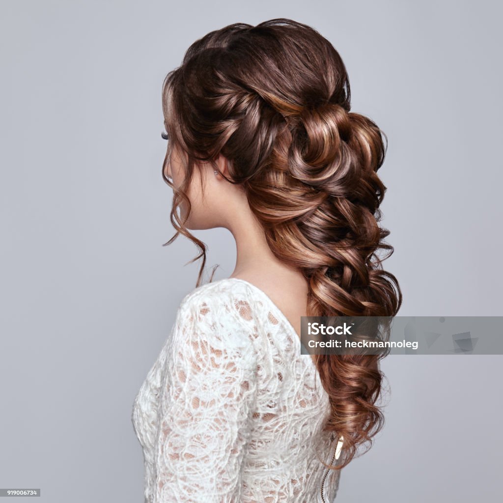 Brunette woman with long and shiny curly hair Brunette Woman with Long and shiny Curly Hair. Beautiful Model Lady with Curly Hairstyle. Care and Beauty Hair products. Care and Beauty of Hair Bride Stock Photo