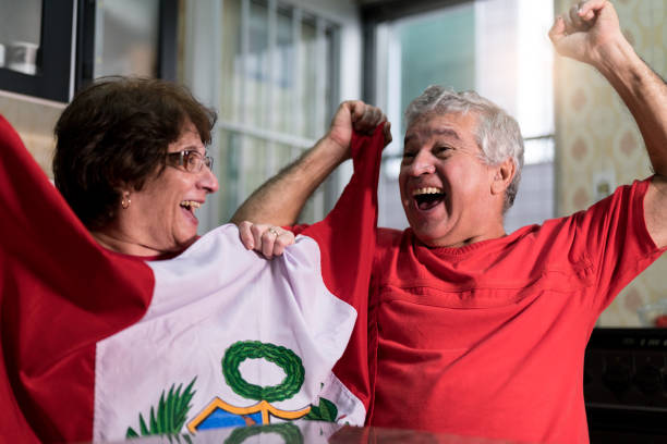 istock Peruvian senior couple fan watching soccer game at home 919014656