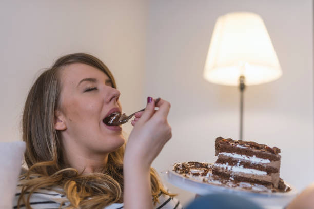 istock Pretty young woman eats a sweet cake 919098418