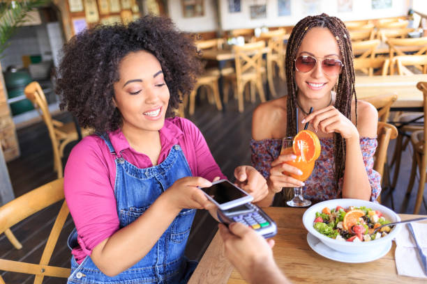 istock Women using smart phone for mobile payment in restaurant 919109674