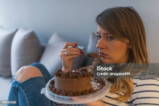 Deprimida Mujer Come Torta Foto de stock y más banco de imágenes de Comer - Comer, Tristeza, Alimento