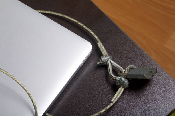 istock Computer security. Protection of access to data. The laptop is protected by a security cable and a lock. Restricting access to the computer. 919131536