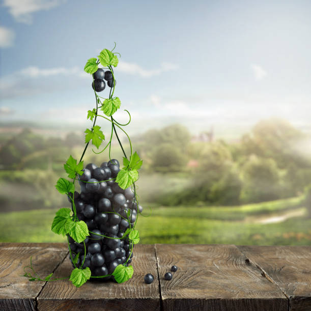 bottle of wine made from grapevine and grapes on an old wooden background