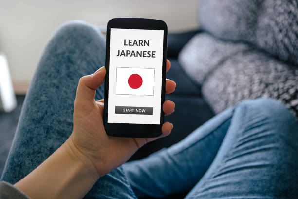 istock Girl holding smart phone with learn Japanese concept on screen 919151256