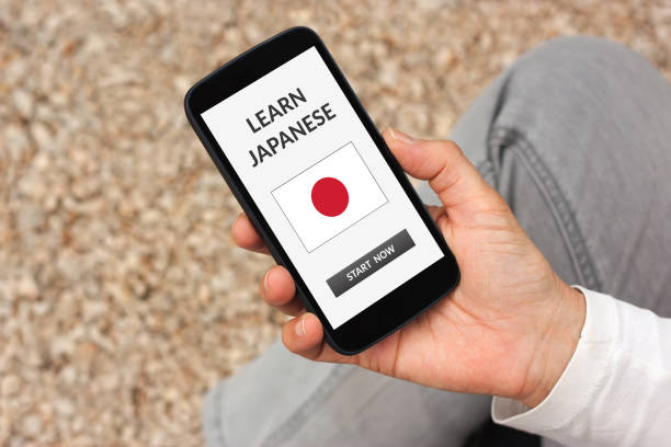 istock Hand holding smart phone with learn Japanese concept on screen 919151264