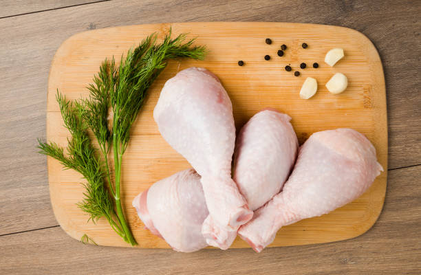istock raw chicken legs on wooden board 919158134